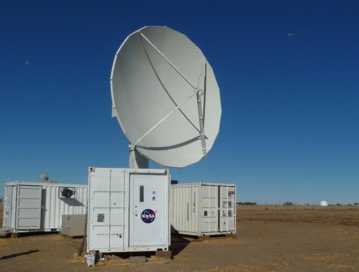 The NPOL instrument, a large radar dish attached to a trailer under a blue sky